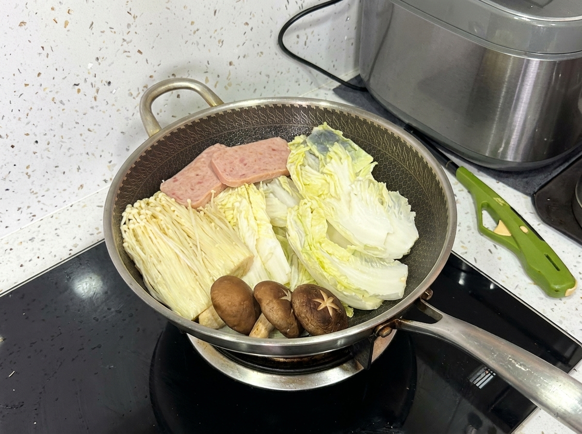白菜、エノキタケ、シイタケ、ランチョンミート、豚肉のスライスが綺麗に並べられた中華鍋。