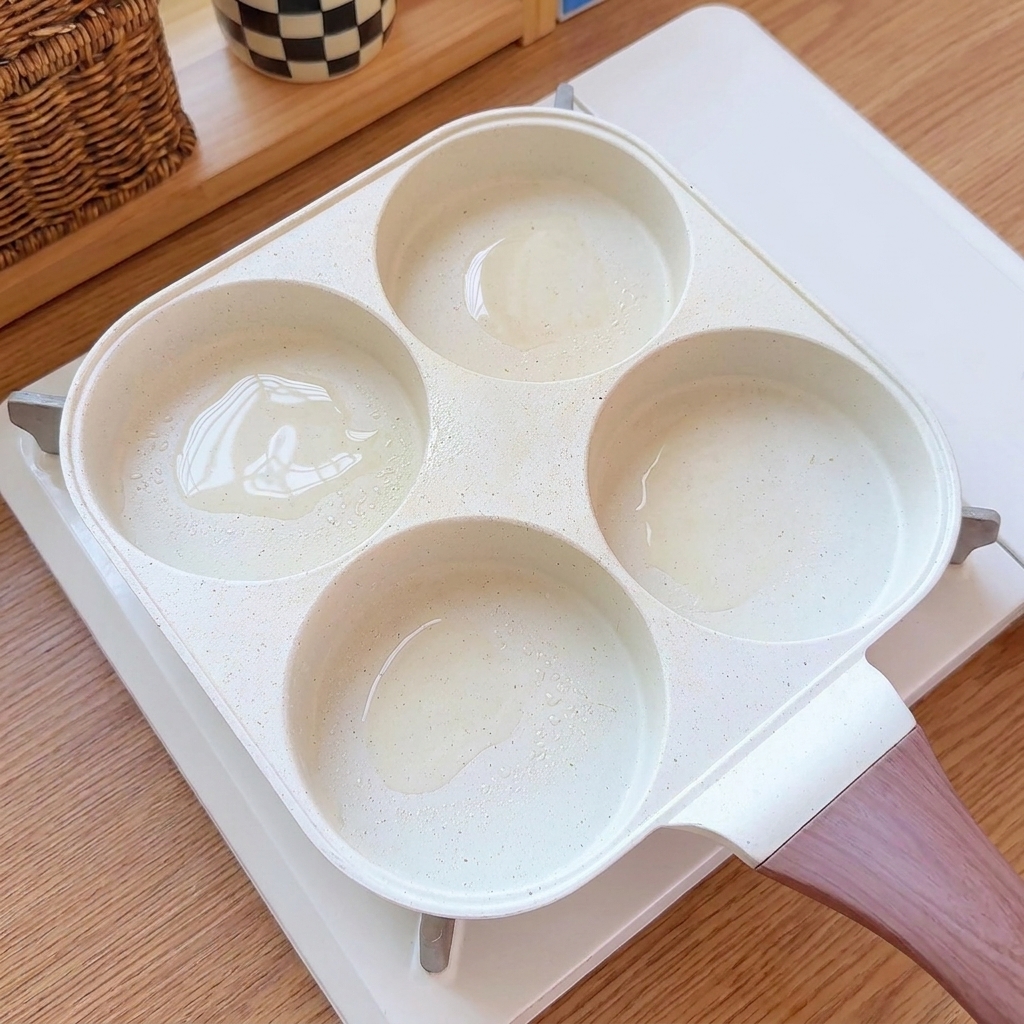 マルチカップフライパンの油を引いた各くぼみに、卵液が注がれている様子。