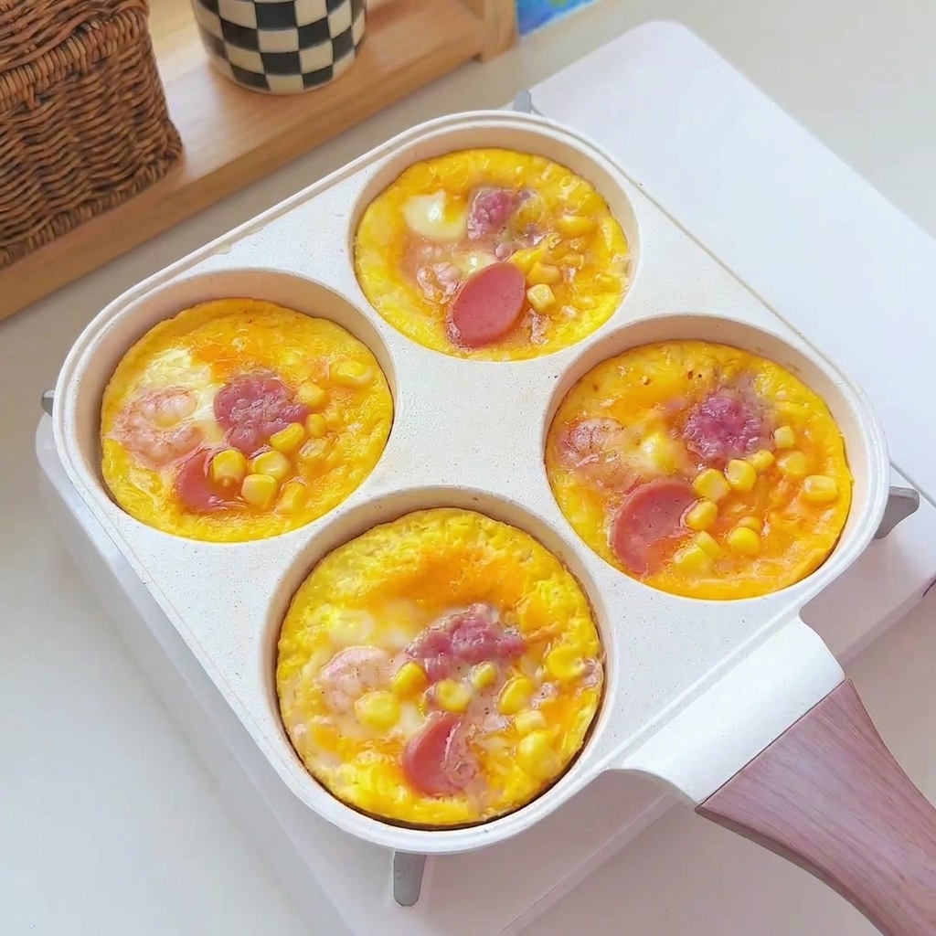 丸く焼き上がった卵パティが、フライパンから白いサービングプレートに移されている様子。