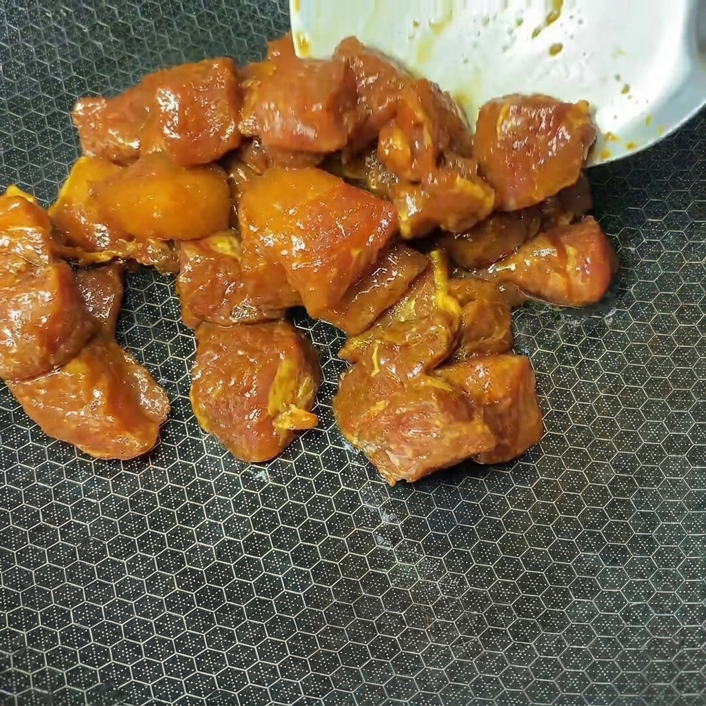熱した中華鍋に下味をつけた豚肉を入れている様子。