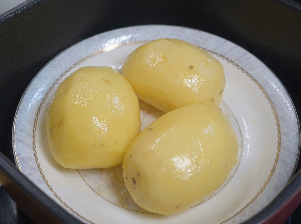 お皿の上に並んだ、油を塗る準備ができた蒸しじゃがいも。