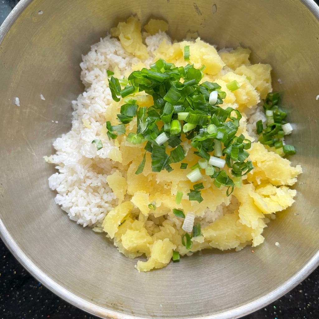くり抜いたじゃがいも、調味料、ご飯をボウルで混ぜ合わせる様子。