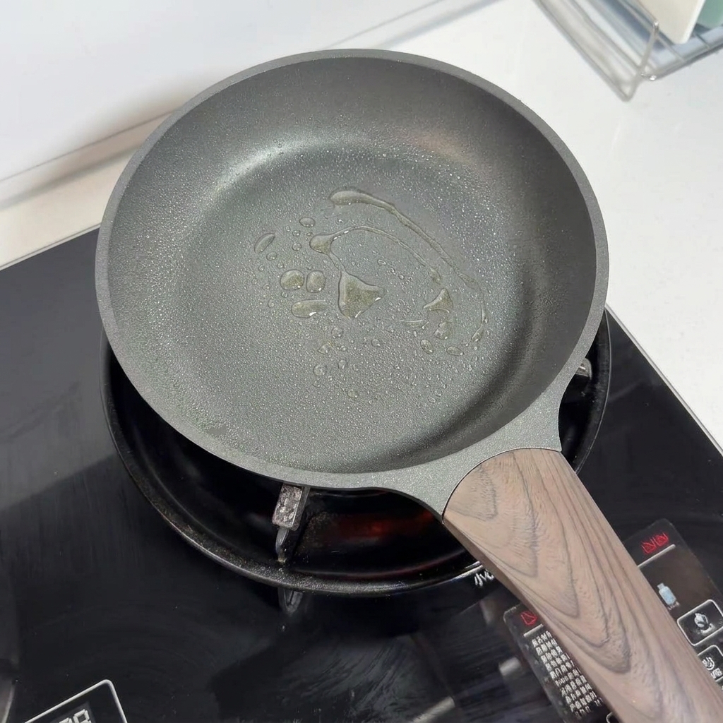 底面に油がスプレーされた、調理前のノンスティックフライパン。