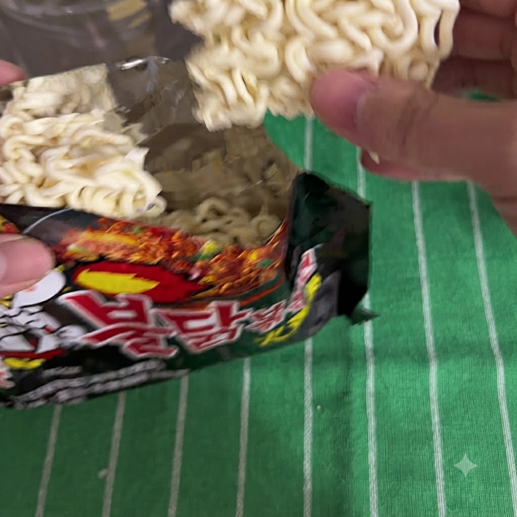 黒いパッケージからインスタントラーメンを取り出している様子。