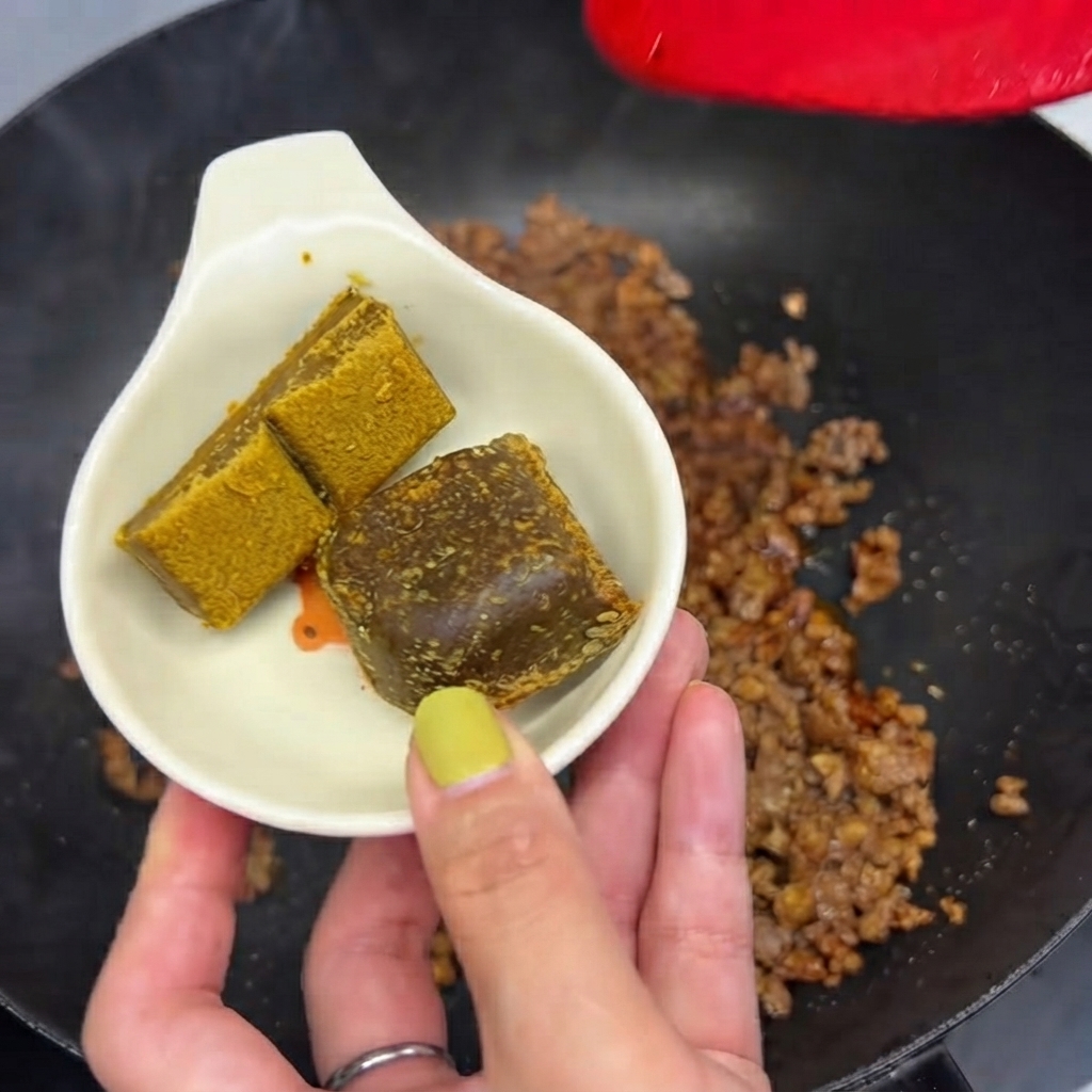 ひき肉の入ったフライパンに入れる直前の、小さな白い皿に置かれた2つのカレールー。