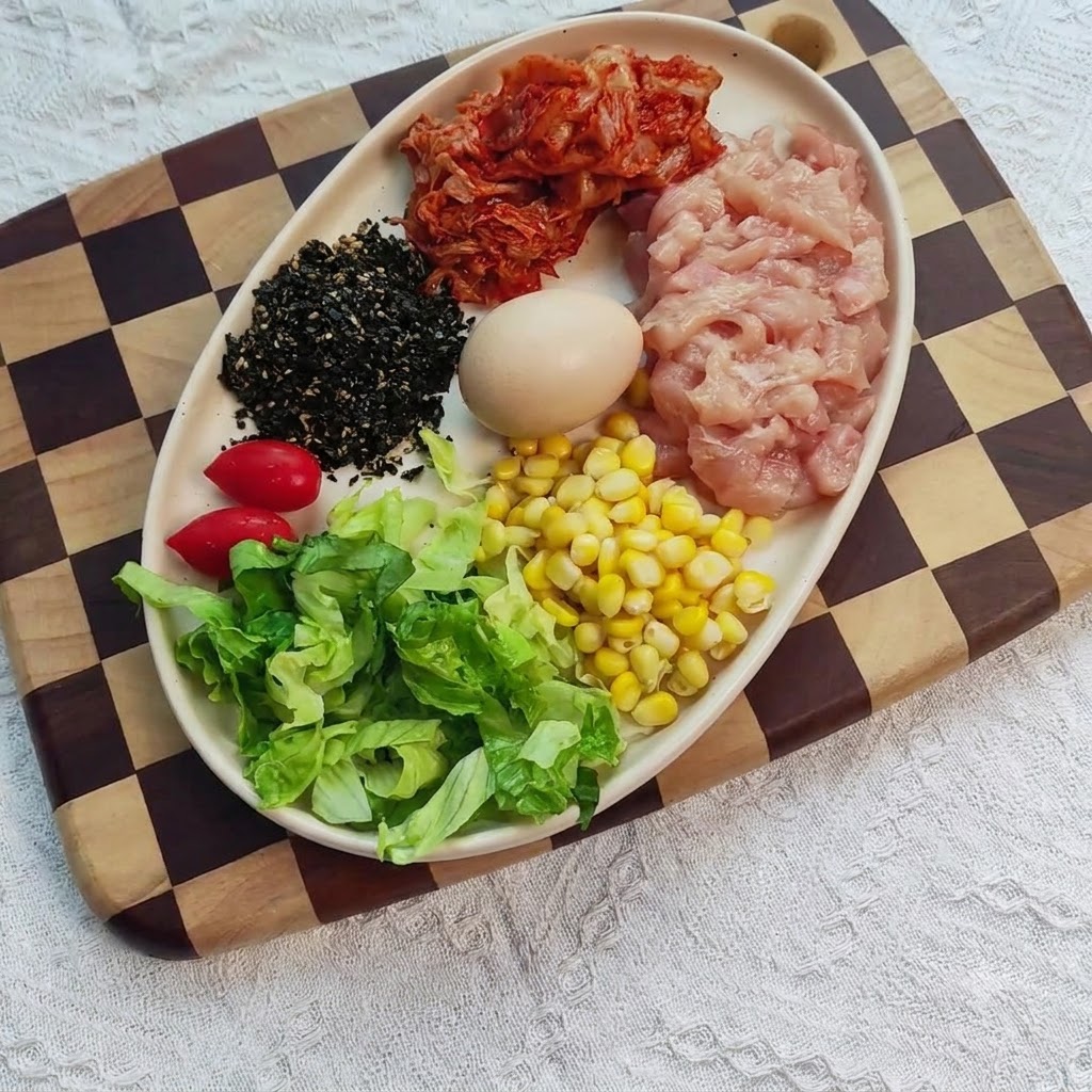 ボウルに入れられ、調味料、生姜、にんにくと混ぜ合わされた鶏むね肉のダイス。