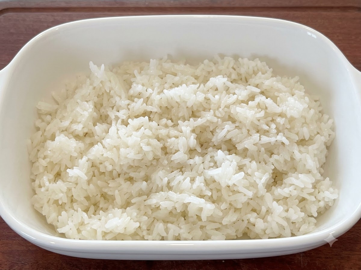 白い器に入った炊き立てのご飯に、ごま油といりごまが混ぜ合わされている様子。
