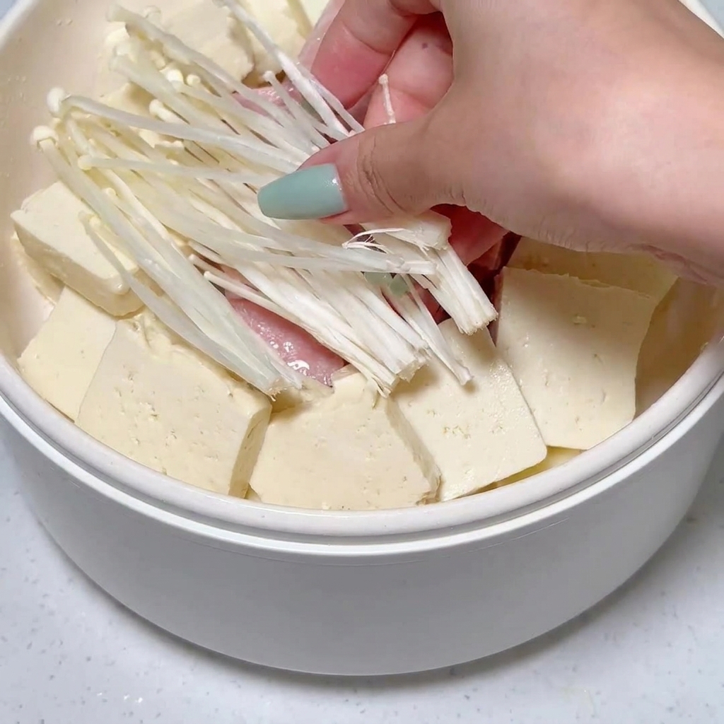 並べられた豆腐とランチョンミートの隙間に、エノキタケが入れられている様子。