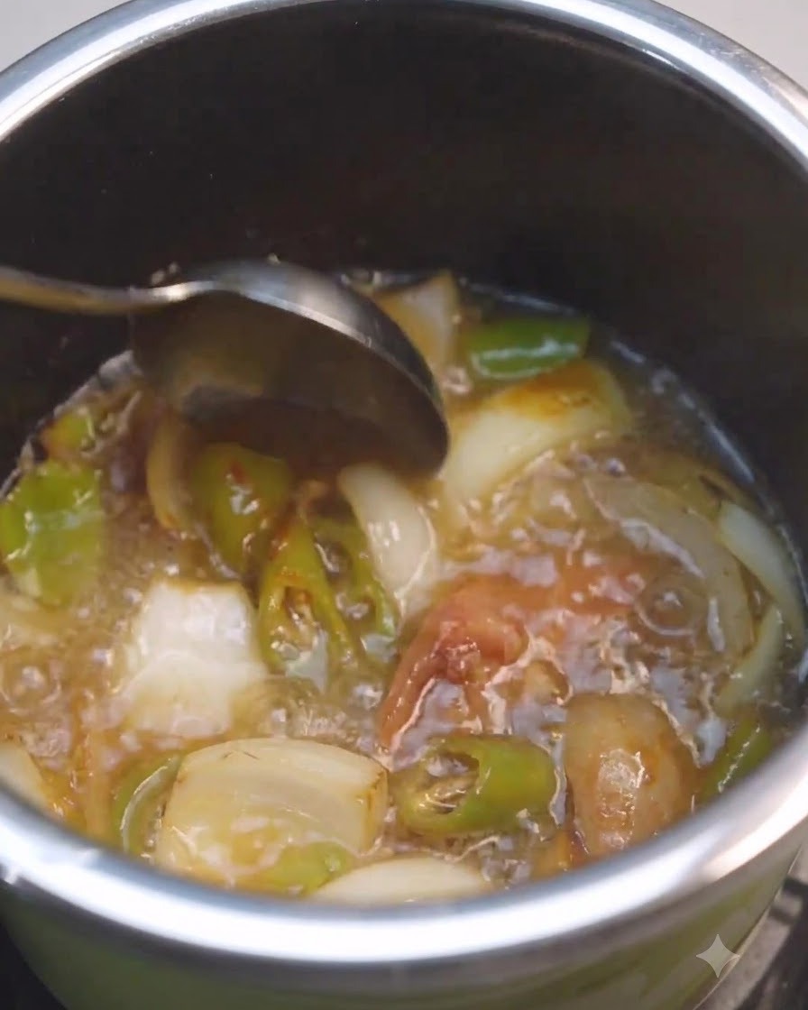 野菜が入った鍋の中で、液体と韓国味噌をスプーンで混ぜ合わせている様子。