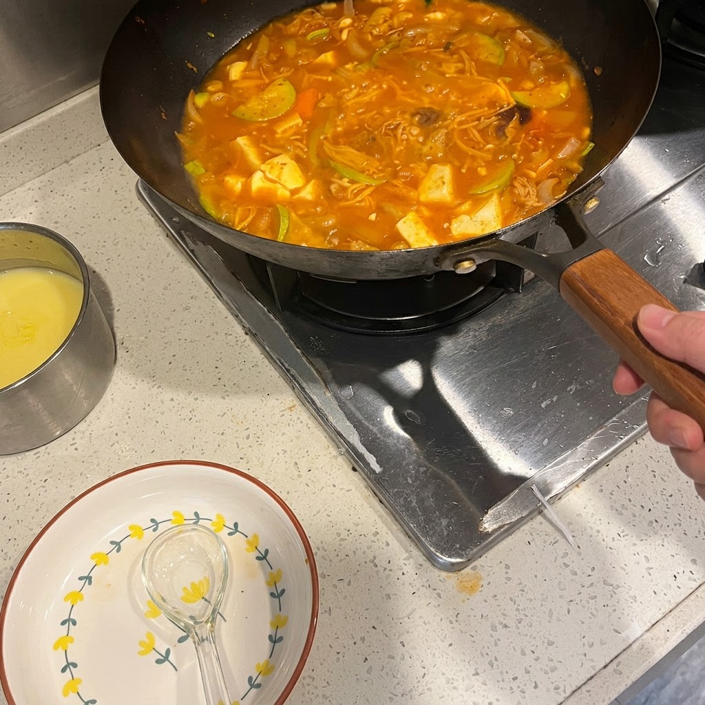 野菜や肉が入った煮込み中のピリ辛スープに、コチュジャンを溶かし入れている様子。