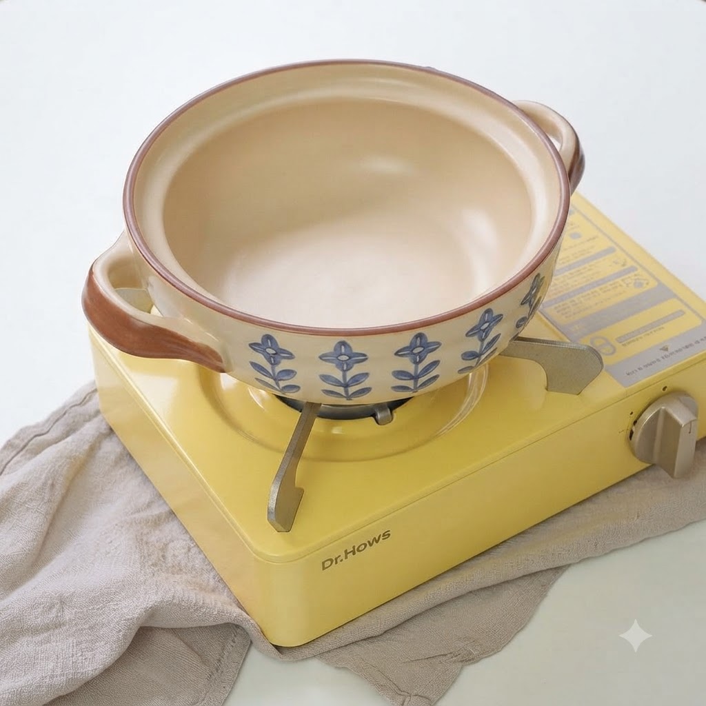 油を引いた土鍋で、長ねぎとにんにくのスライスがジュージューと音を立てて炒められている様子。