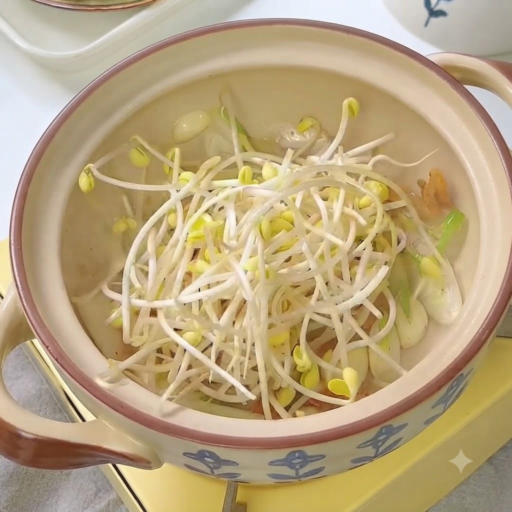 キムチと香味野菜が入った鍋に新鮮なもやしが入っている様子。