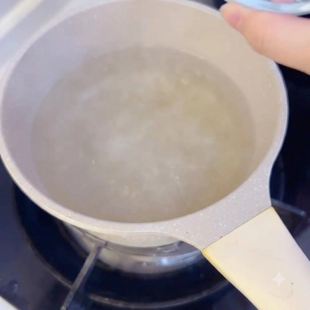 コンロの上の沸騰したスープの鍋に、スライス餅を入れているところ。