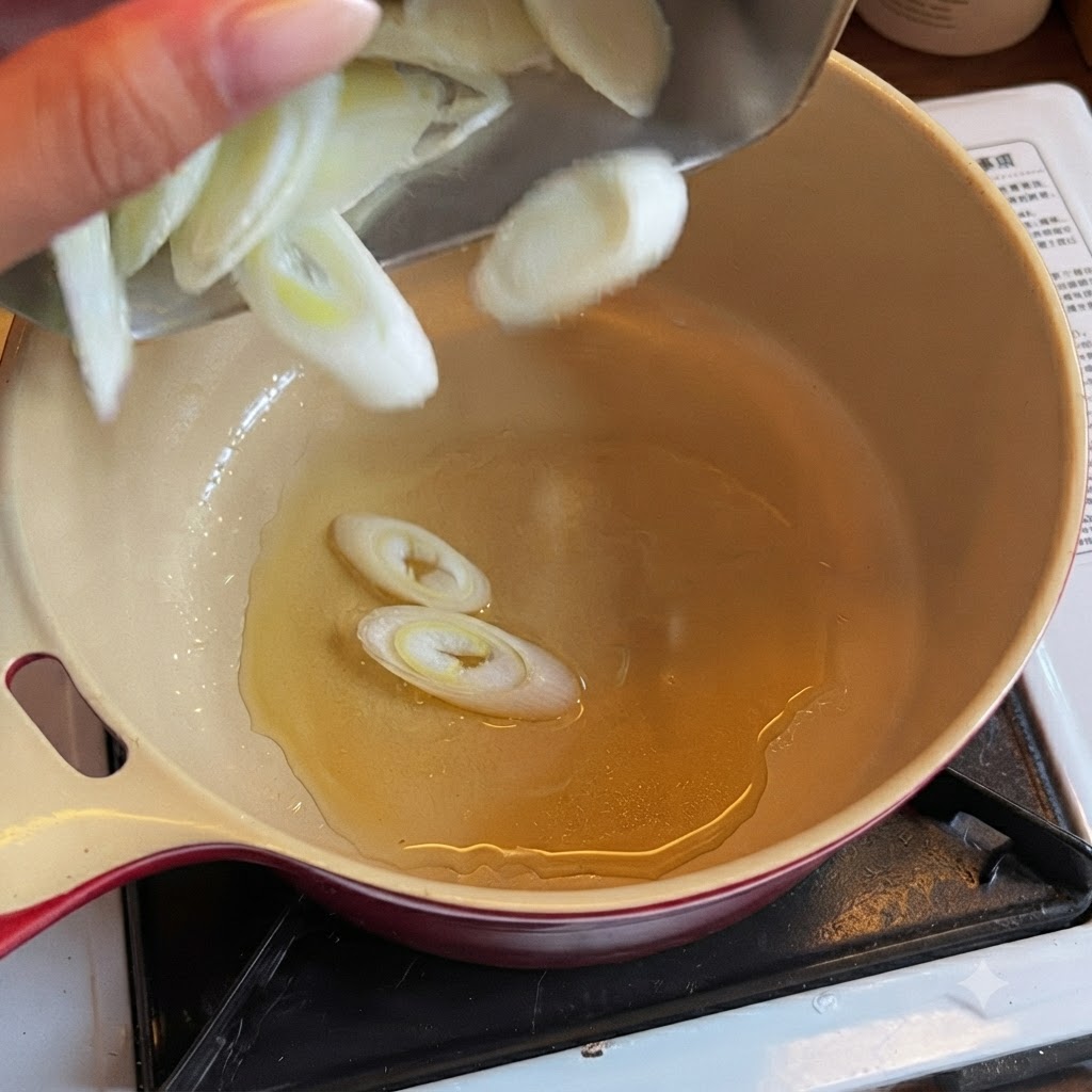 調理油が入った鍋にスライスしたネギを入れている様子。