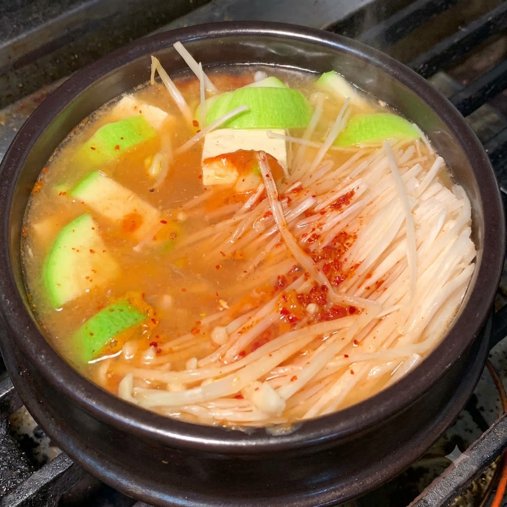 味付けされたスープの中で具材が煮込まれている土鍋のクローズアップ。