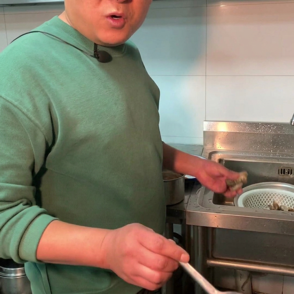 味噌スープが煮立つ鍋の中に、新鮮なあさりを投入している様子。