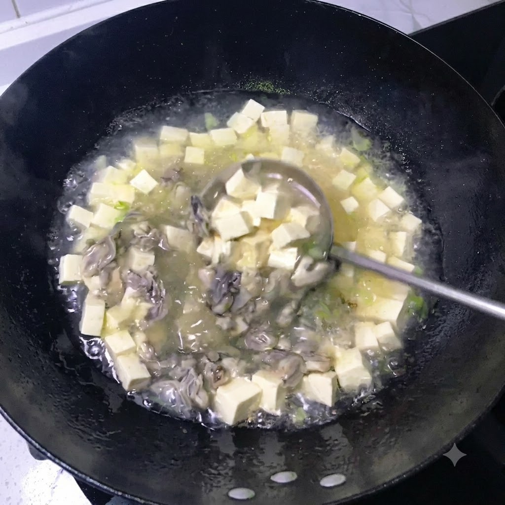 黒い中華鍋の中で、豆腐と火が通った牡蠣が入った乳白色のスープをおたまですくい混ぜている様子