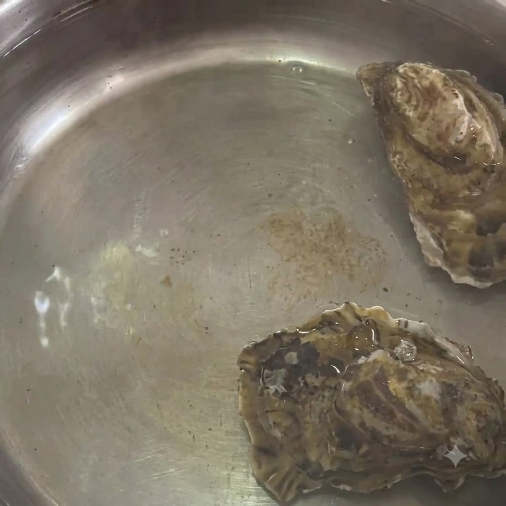 ステンレス鍋の熱湯の中で茹でられている牡蠣
