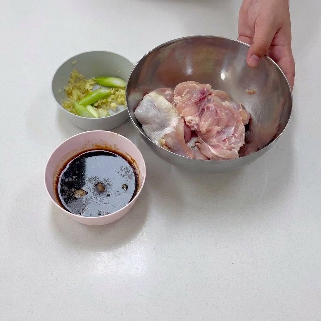 下準備中、ステンレスのボウルに入った骨なし鶏もも肉。