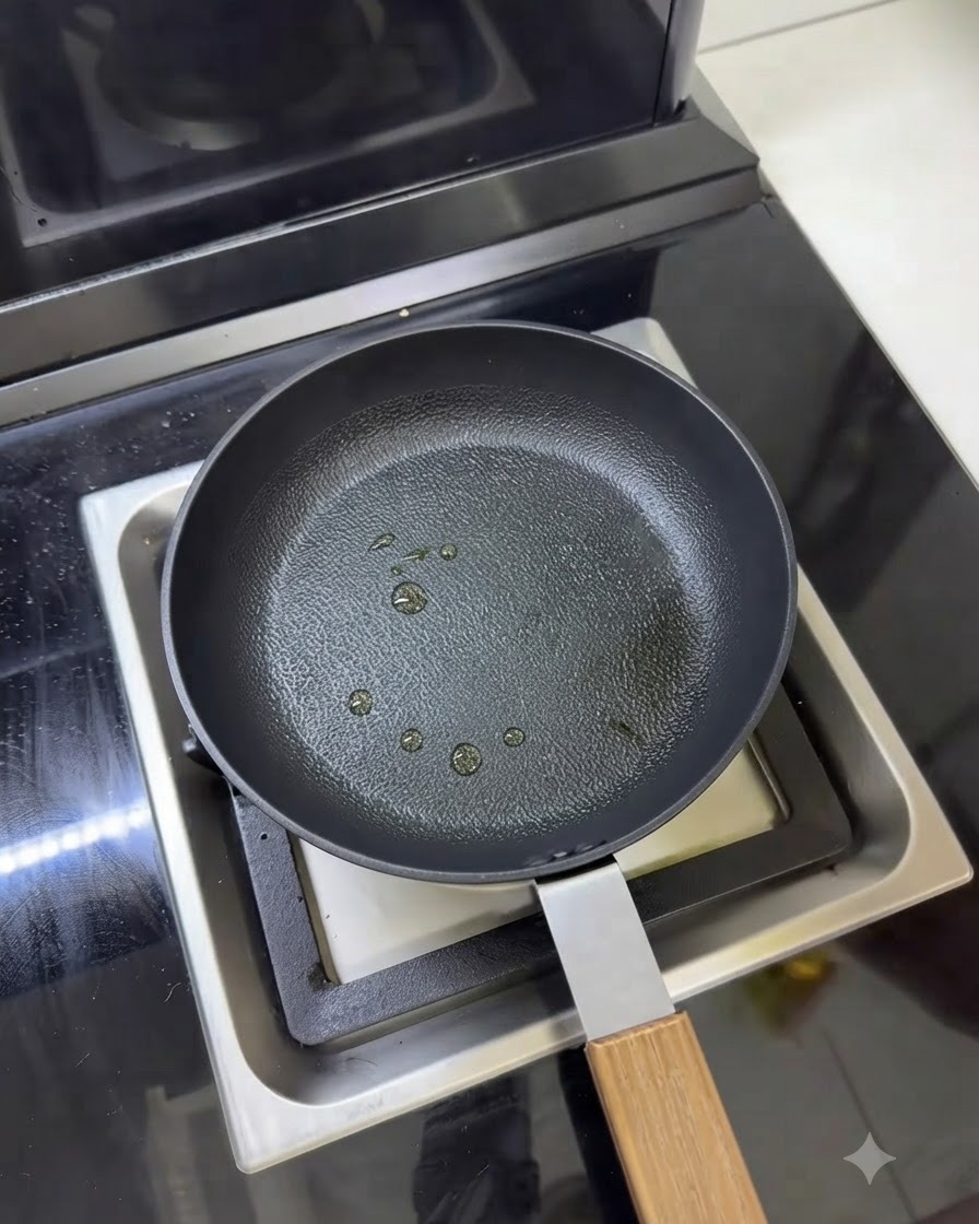 表面に小さな調理油の液滴がスプレーされたフライパン。