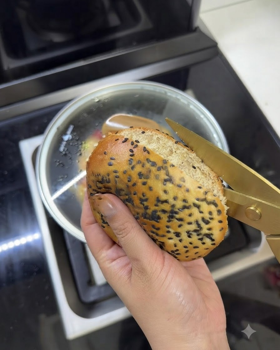 温かいバターバーガーバンズが、金色のキッチンバサミで慎重に切り開かれている様子。