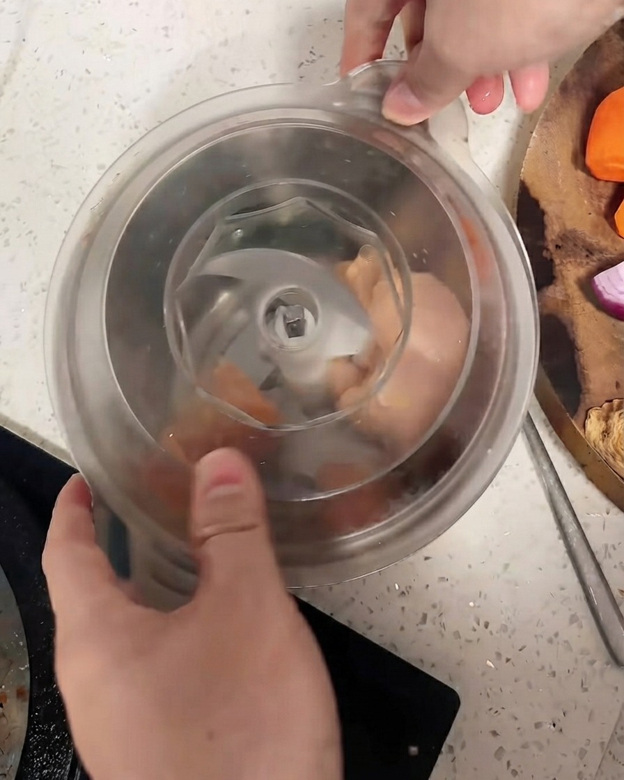 鶏肉の上に蓋がしっかりと閉められたフードプロセッサー。