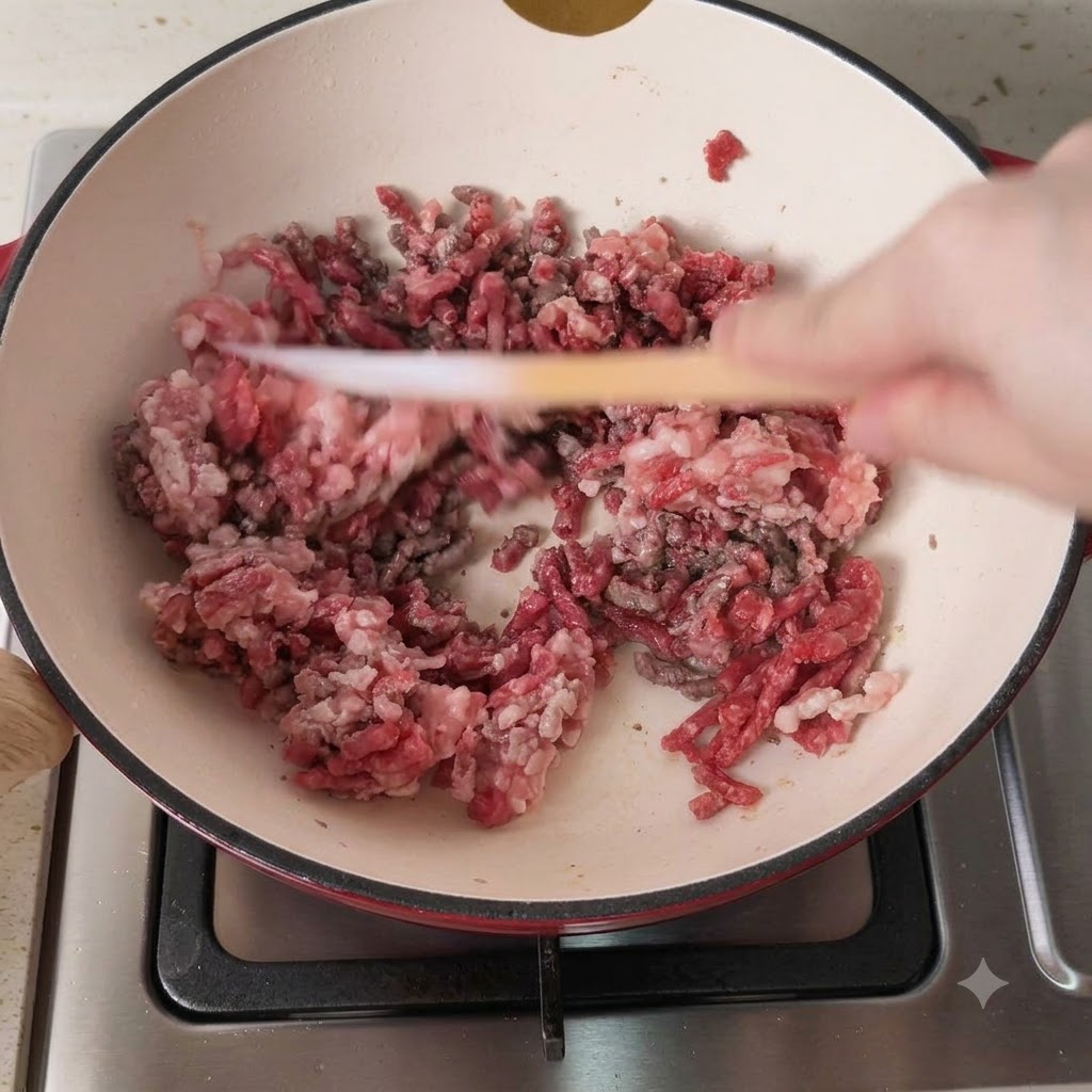 熱した鍋で豚ひき肉と牛ひき肉のミックスが炒められている様子
