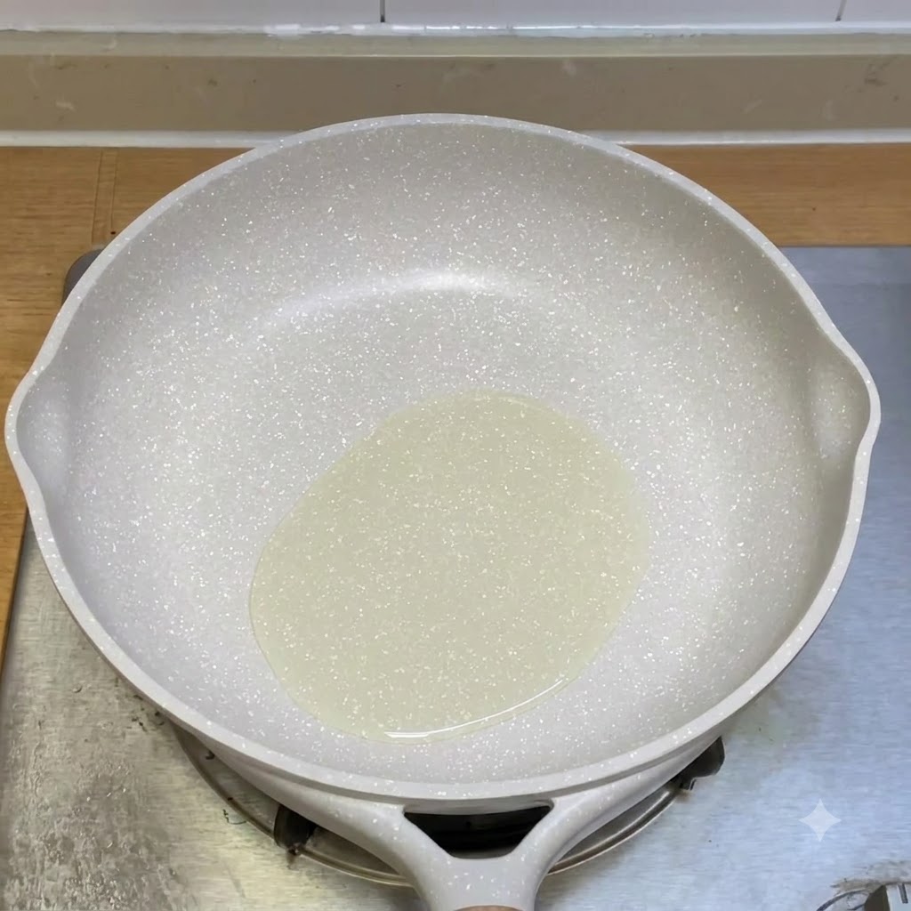 白いフライパンの中で油と一緒に炒められているひき肉。