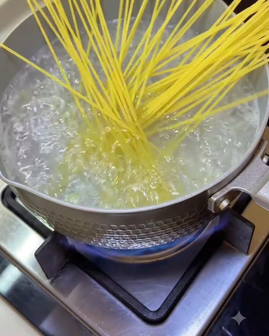 沸騰したお湯の入った鍋にスパゲッティを入れている様子。