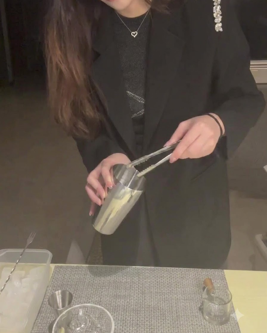 トングを使って金属製のシェイカーに氷を入れている様子。