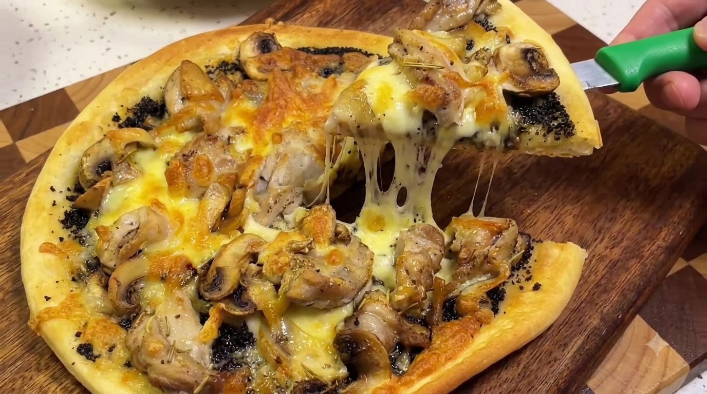 チーズがたっぷり伸びて黄金色に焼き上がった、焼きたての黒トリュフチキンピザcite: 1。