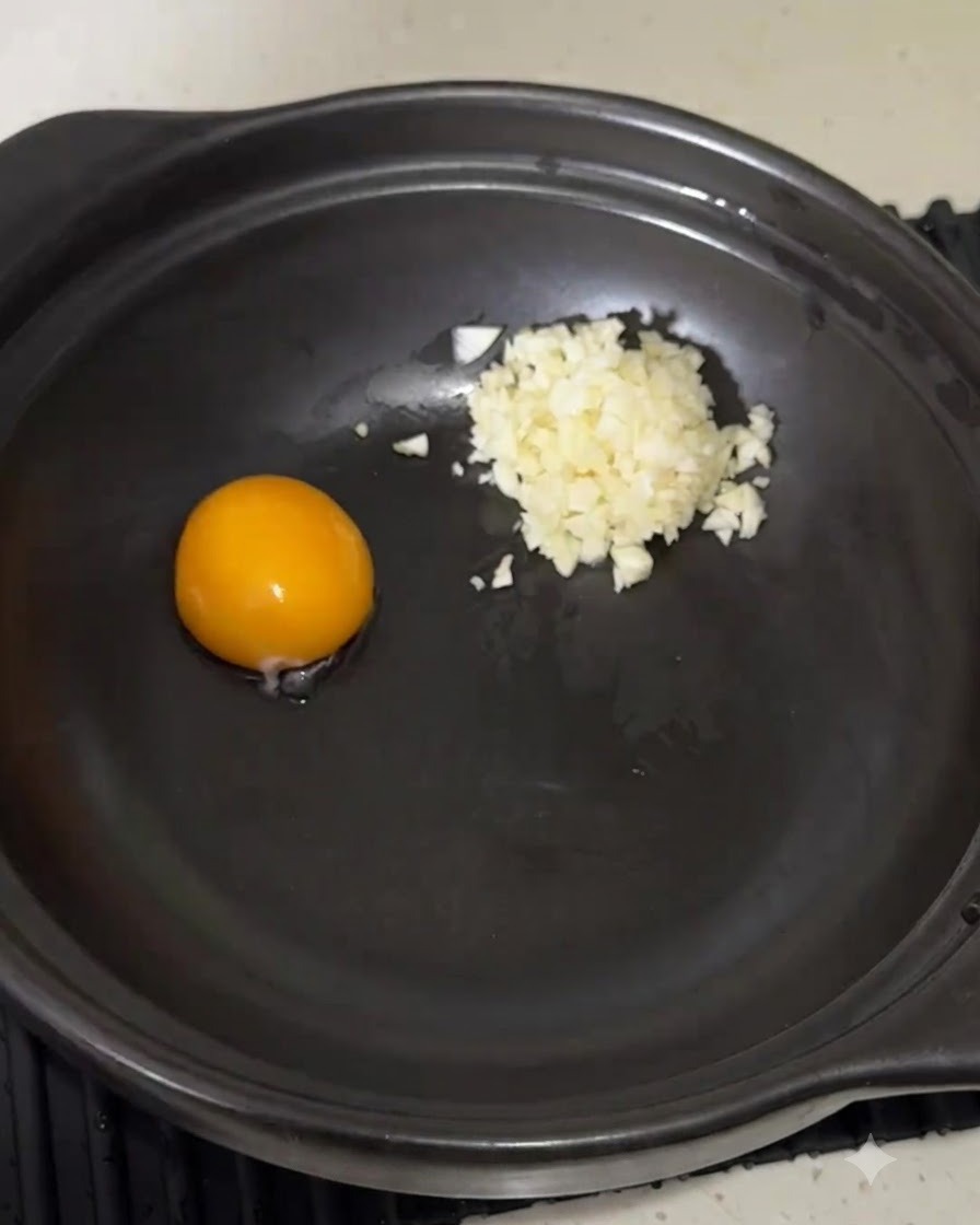 卵黄とにんにくが入った鍋に粉末スープを入れている様子。