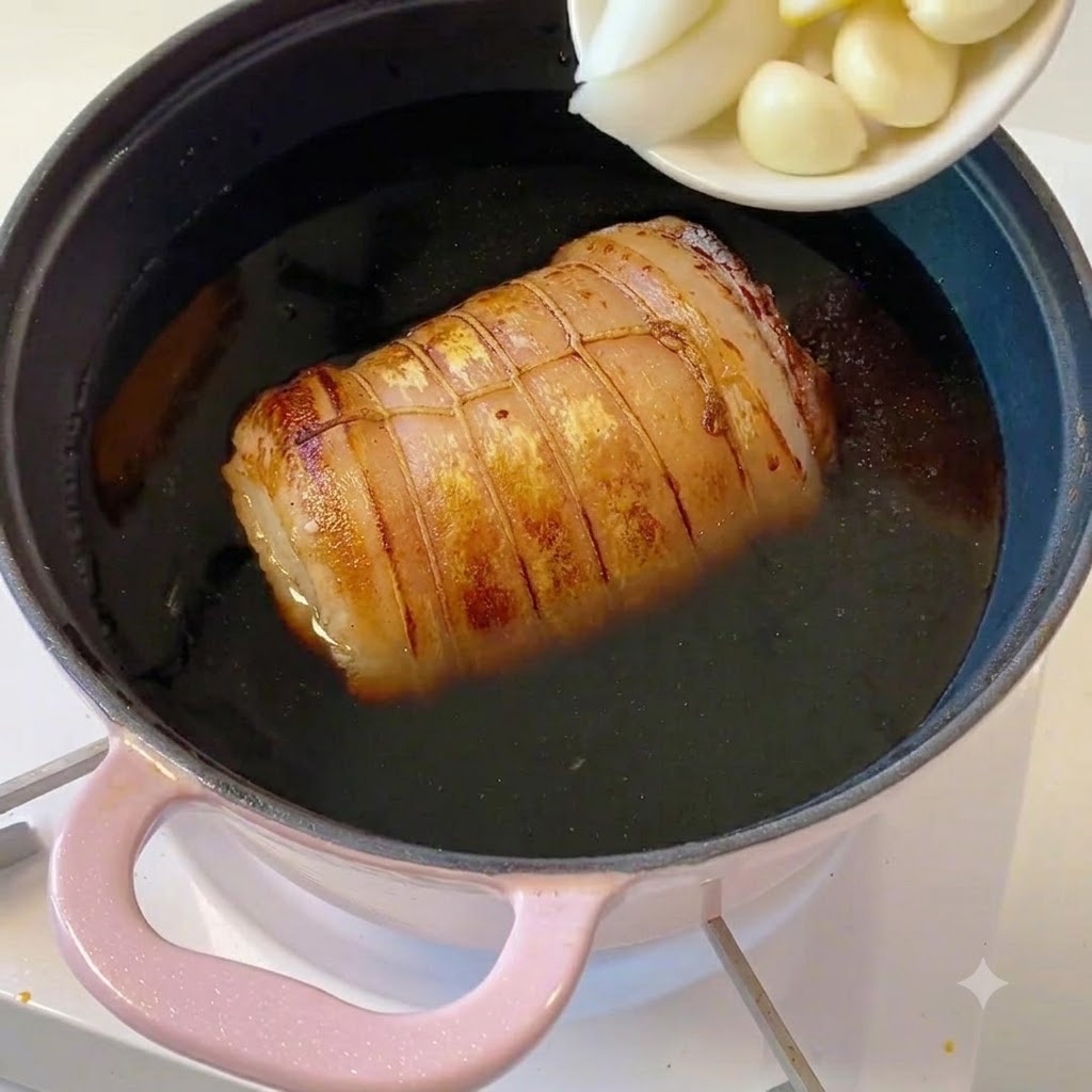 スライスしたネギ、生姜、ニンニクが乗った白い小皿から、具材が鍋に入れられている様子。