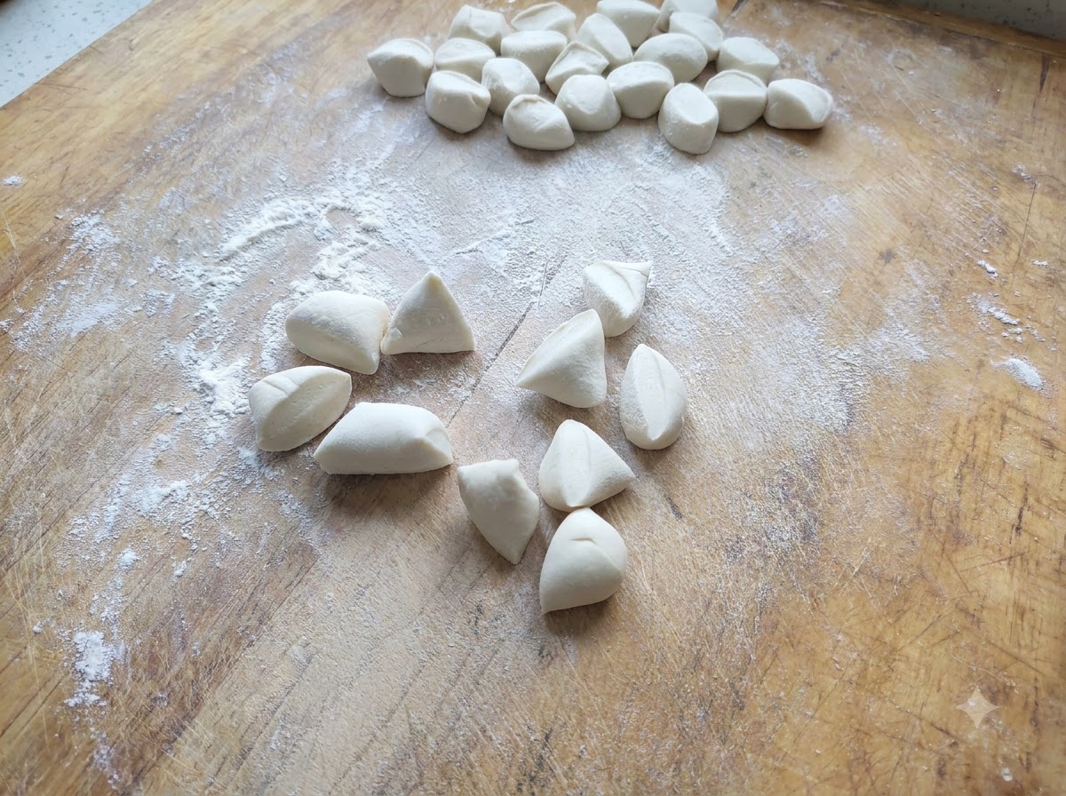 小麦粉を振った木製の台の上に、小さく切られた白い餃子の生地が散らばっている様子。