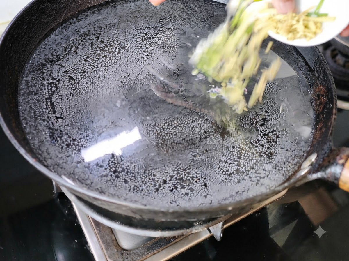 コンロ上の水が入った中華鍋に、刻んだネギと生姜を入れている様子。