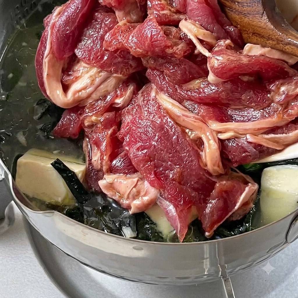 弱火で煮立つスープの中に、下味をつけた牛肉のスライスが落とし入れられている様子。