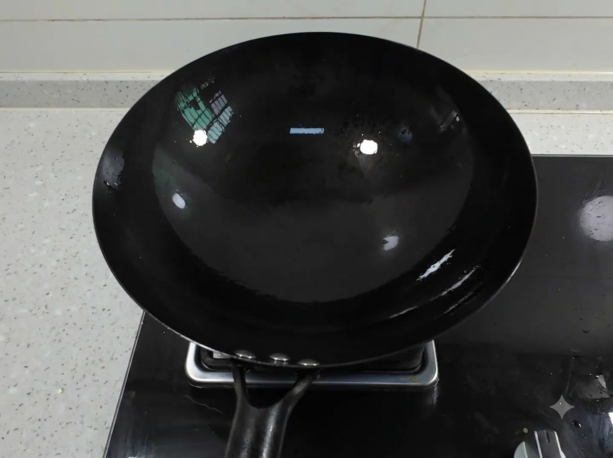 ガスコンロに乗せた黒い鉄製の中華鍋に油を注いでいる様子。