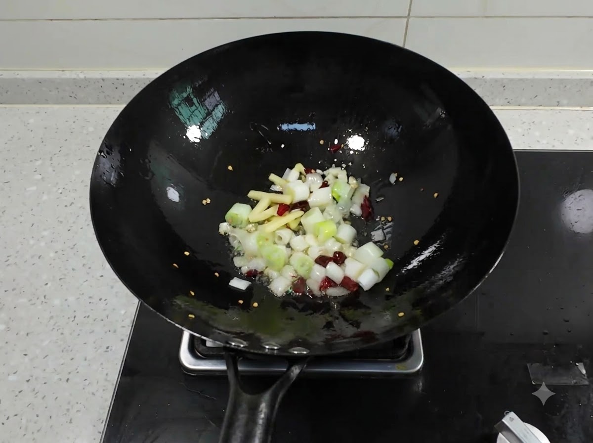 熱い油が入った中華鍋で、刻んだねぎ、生姜、にんにく、乾燥唐辛子がパチパチと音を立てている様子。