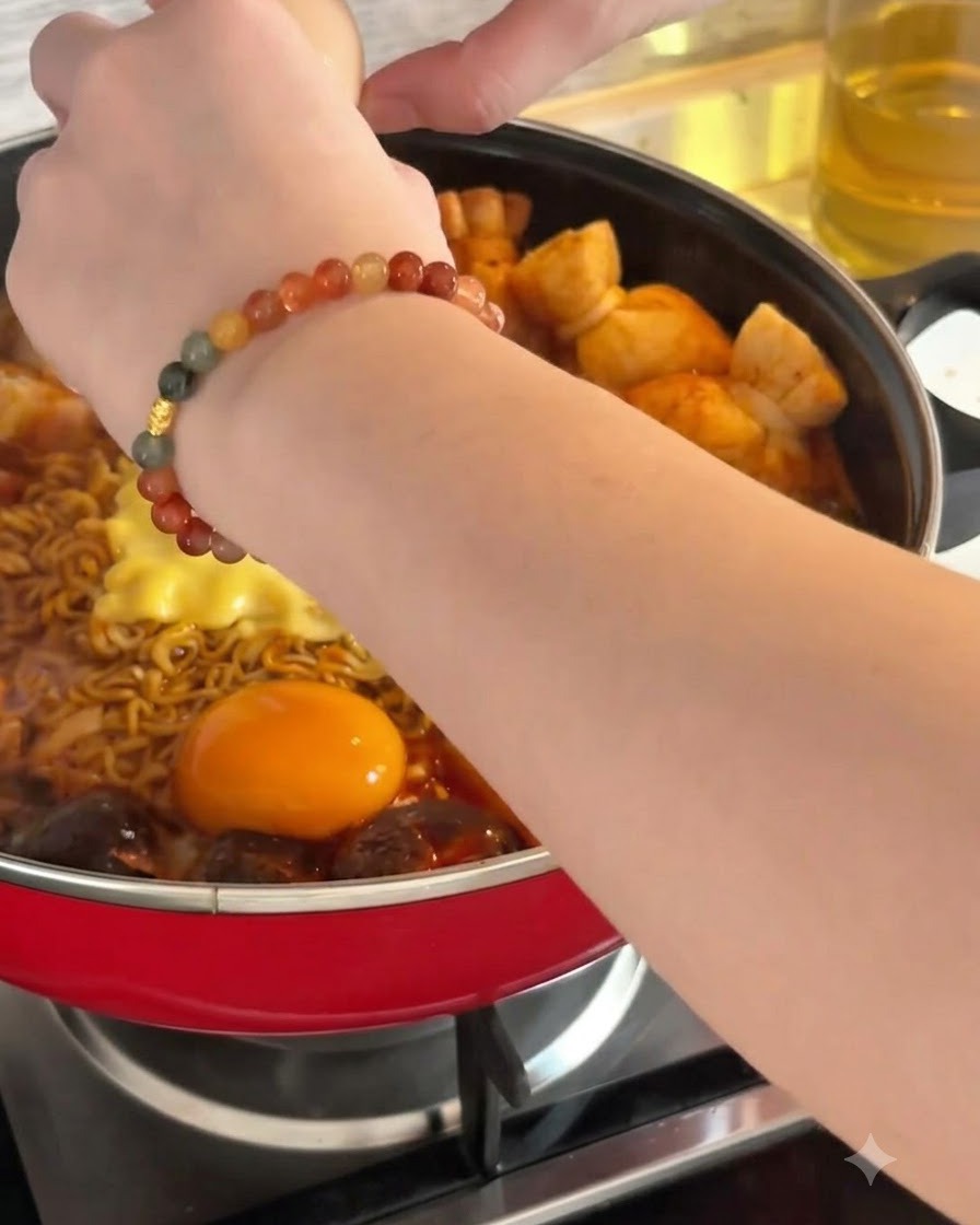 麺やチーズの横にある熱いスープの中に、生卵を割り入れている様子。