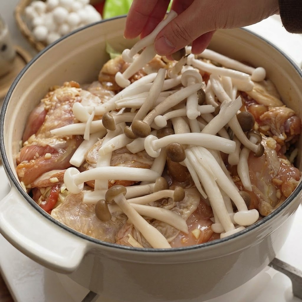 ほぐしたしめじと飾り切りしたしいたけを、鍋の中の鶏肉の上に並べている様子。