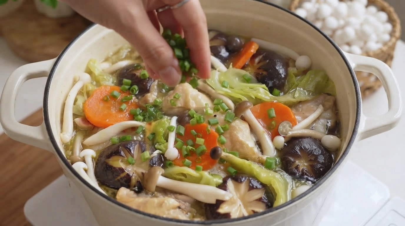 刻み青ねぎを散らした、グツグツと温まる色鮮やかな無水鶏肉と野菜の鍋