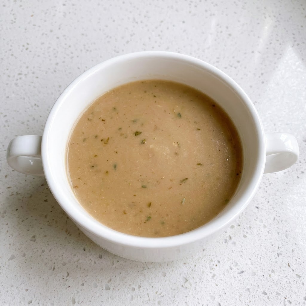 黒こしょうの粒が混ざった茶色いソースが入った白いボウル。