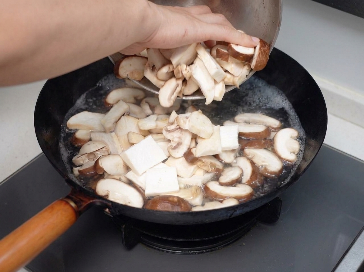 スライスしたミックスキノコを沸騰したお湯の入った鍋に投入している様子。