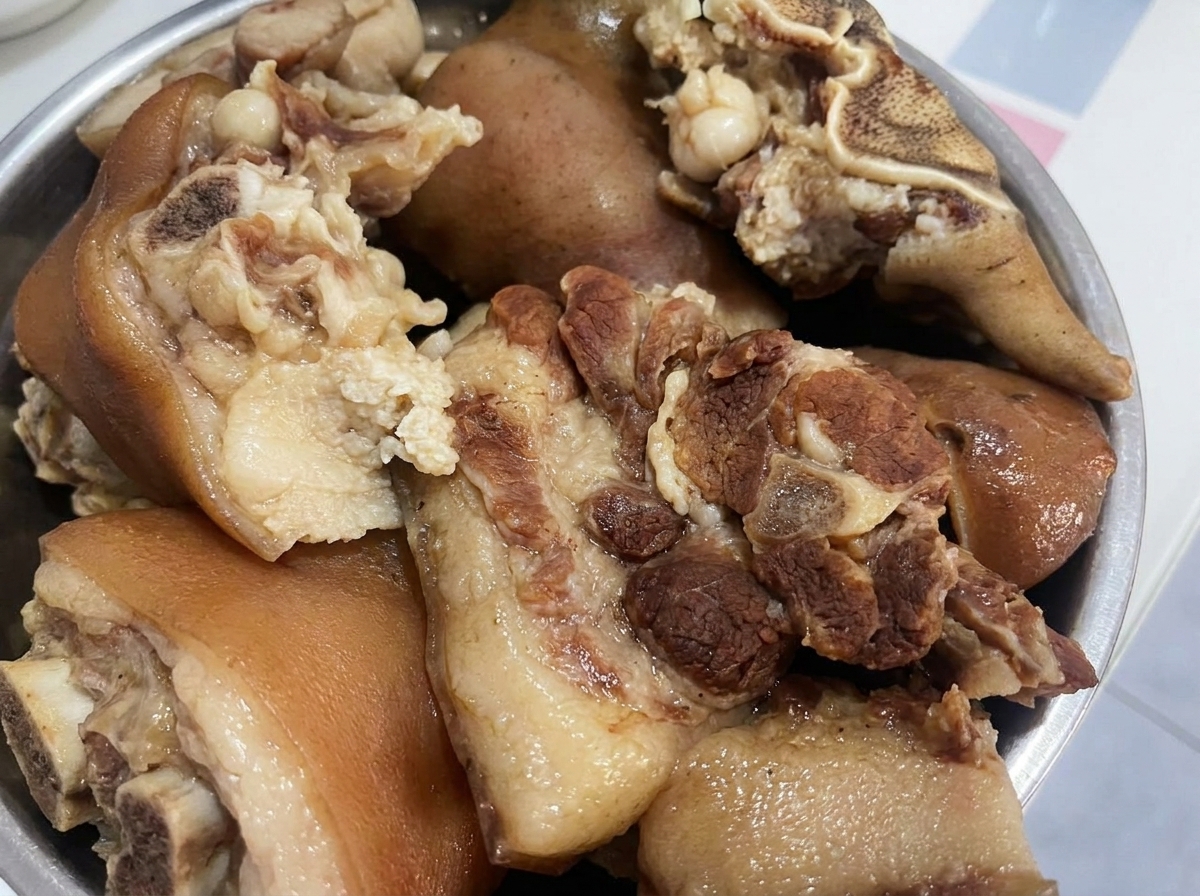 小さく切り分ける準備ができ、ボウルに入った調理済みの豚肉の塊。