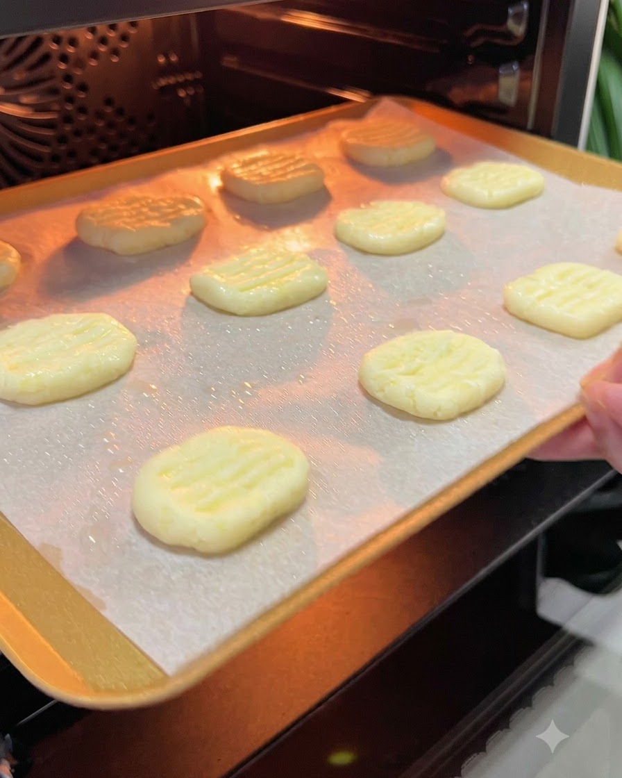 オイルをスプレーしたポテトパンケーキを載せた天板を、予熱されたオーブンの温かな庫内へ滑り込ませている様子