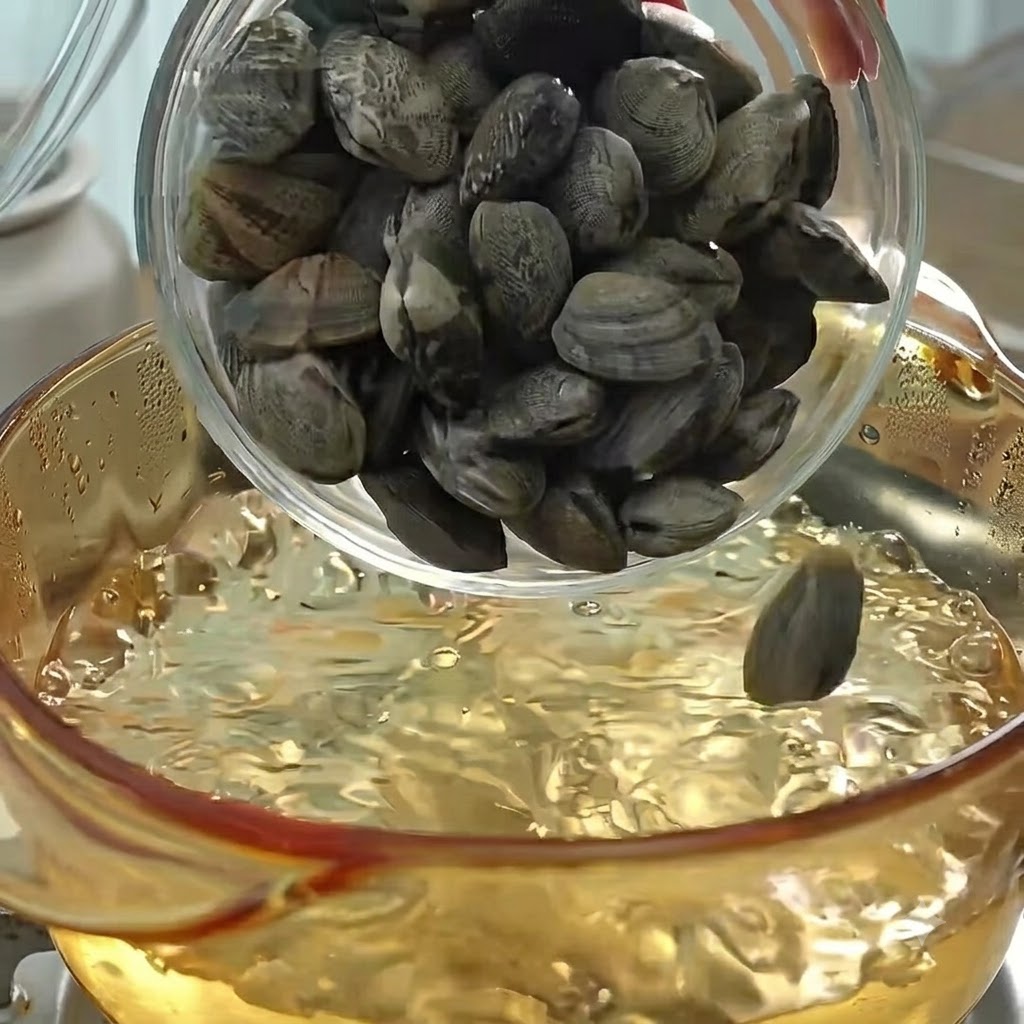 沸騰したお湯の入った鍋にアサリを入れ、煮込んでだしを取っている様子。