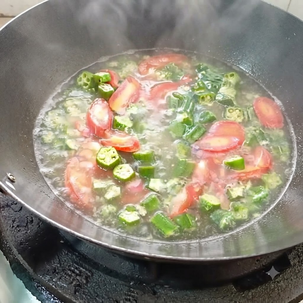 炒めた野菜が入った中華鍋に、沸騰したお湯を注ぎ入れているところ。
