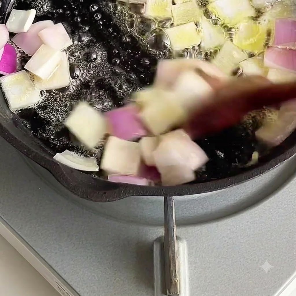 溶けたバターの中で角切りの玉ねぎが炒められている様子。