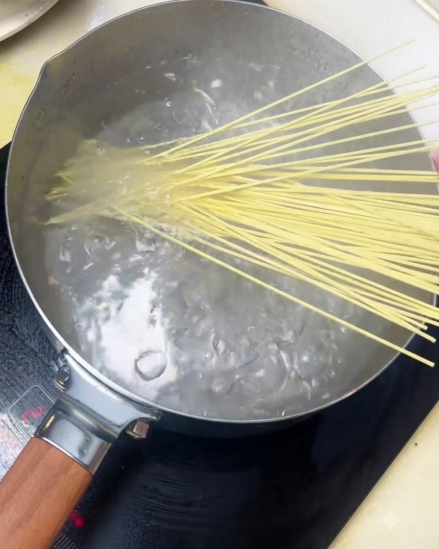 沸騰したお湯の入った鍋に中華麺を入れている様子。