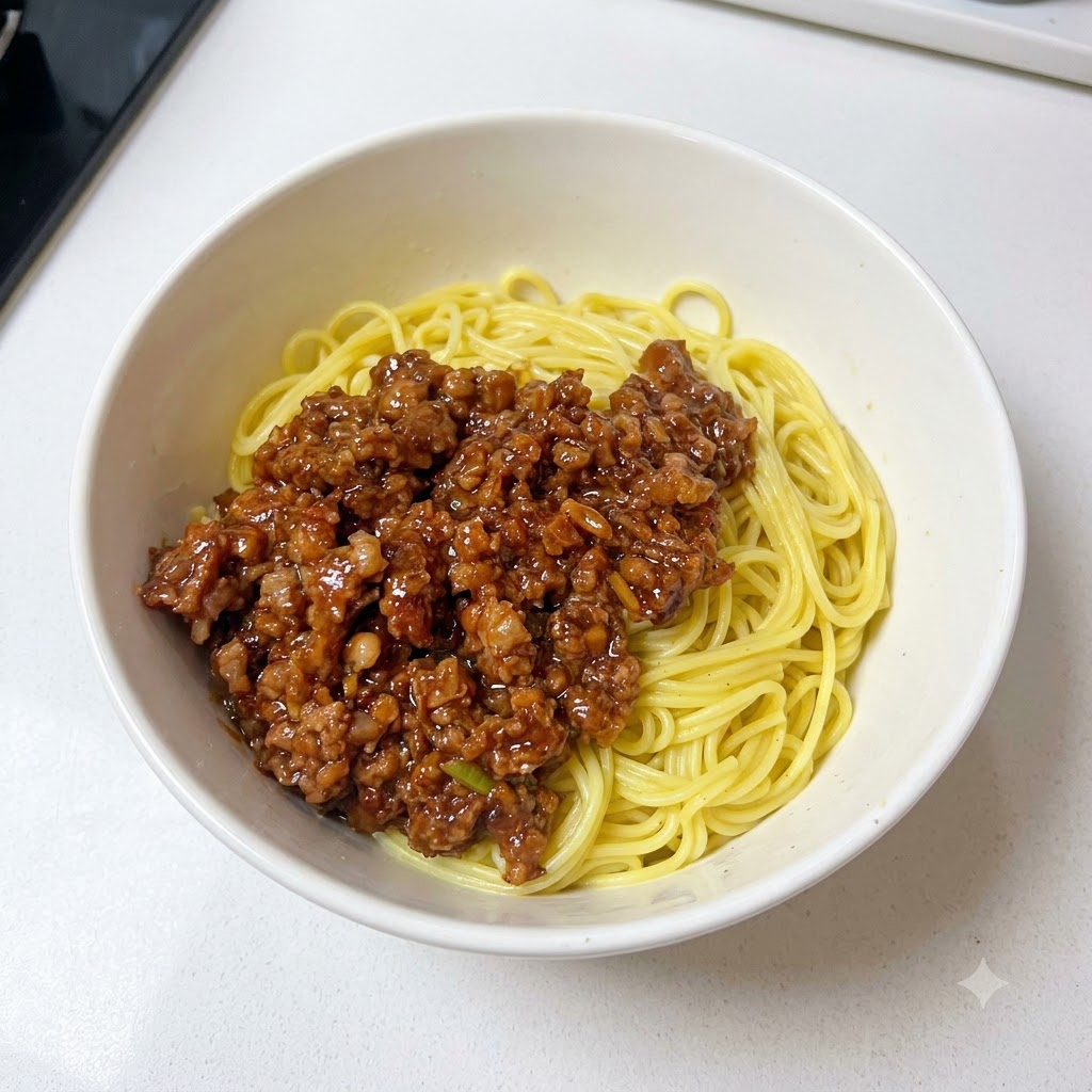 麺と挽き肉ソースの上に刻みネギをトッピングしたボウル。